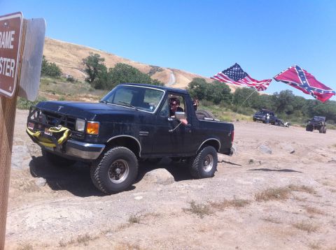 1990 Ford Bronco - This 1990 Ford Bronco is seen off-road with American and Confederate flags displayed prominently.