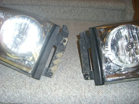 2005 Dodge 3500 - A pair of vehicle headlights are displayed on a carpeted surface.