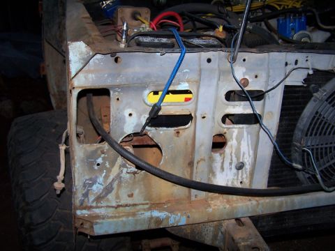 1973 Ford Bronco - Close-up of a vehicle's engine bay, showing the firewall, battery, and wiring.