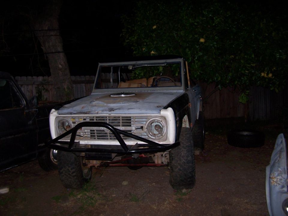 Gray Ford Bronco with aftermarket bumper and roll cage, front view