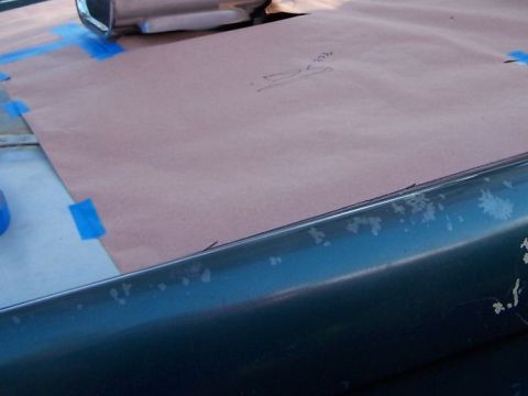 1973 Ford Bronco - A paper template is taped to a car's hood, possibly for a custom modification or repair.