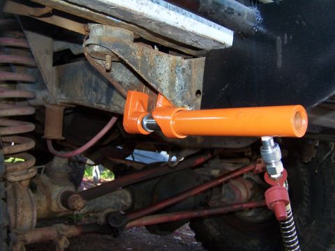 1973 Ford Bronco - An orange hydraulic cylinder is attached to the vehicle's frame, likely for suspension modification or repair.