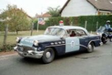 1991 Ford LTD Crown Victoria - This 1955 Buick Special police car is seen from the front-right in a residential area.