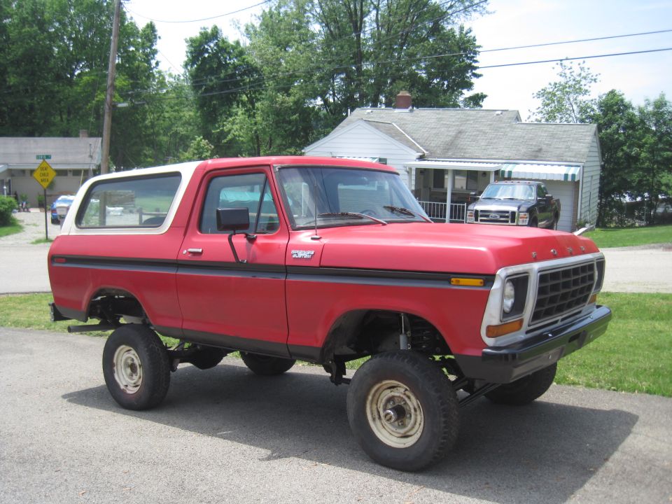 Red 1979 Ford Bronco 3q-front view, lifted with white top