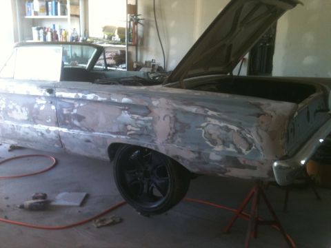 2001 Ford F-350 - A classic car is in a garage, with its hood and trunk open, undergoing repairs and bodywork.
