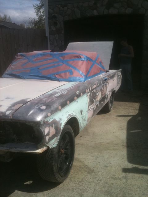 2001 Ford F-350 - A car body, covered in primer and tape, sits in a driveway with a garage in the background.