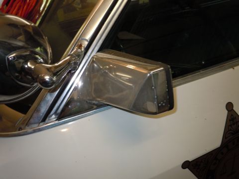 2001 Ford Crown Victoria - Close-up of a chrome side mirror on a white vehicle, part of a star emblem is visible.