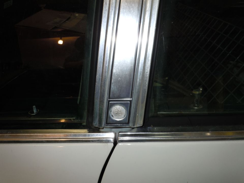 Close-up of chrome trim and window mechanism on a car door