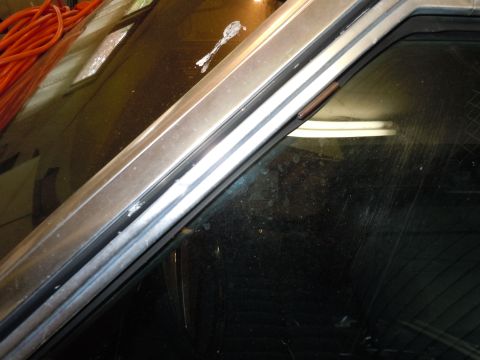 2001 Ford Crown Victoria - Close-up of the car's window frame and windshield, with an orange cord in the background.