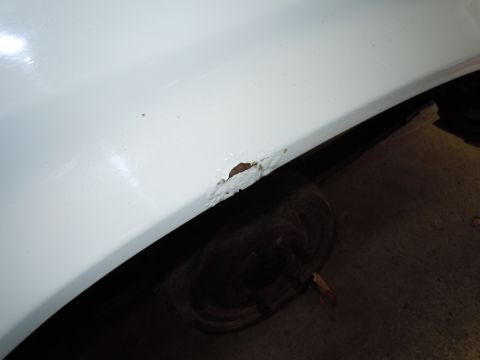 2001 Ford Crown Victoria - Rust damage is visible on the lower body panel of a white vehicle.