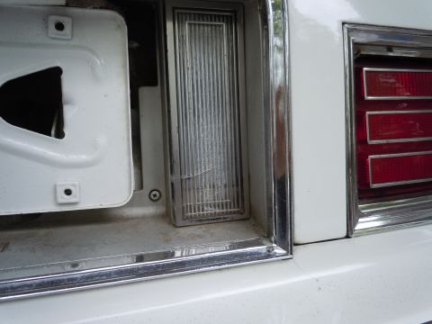 2001 Ford Crown Victoria - Detail of a vehicle's rear lighting components, including a damaged reflector and a portion of the taillight.