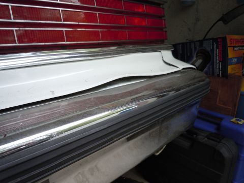 2001 Ford Crown Victoria - Close-up of a vehicle's rear bumper and taillight assembly with chrome trim.