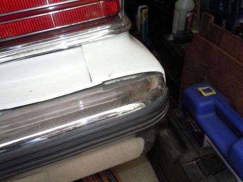 2001 Ford Crown Victoria - Close-up of the rear of a white 2001 Ford Crown Victoria, showing the bumper and taillight assembly.