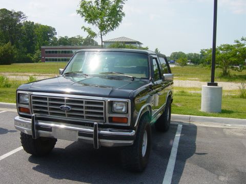1979 Ford Bronco - This black Ford Bronco, likely a 1978 model, is parked in an outdoor lot under a bright sky.