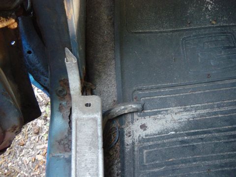 1979 Ford Bronco - Close-up of the interior floor mat and rusted door jamb of a vehicle.