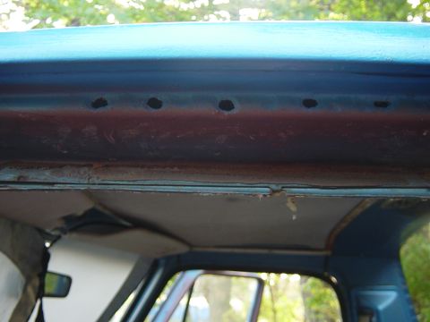 1979 Ford Bronco - Close-up of the interior roofline, revealing rust and several drilled holes.