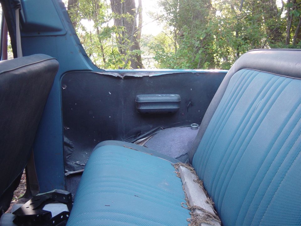 interior view of a blue SUV with worn seats and door panel