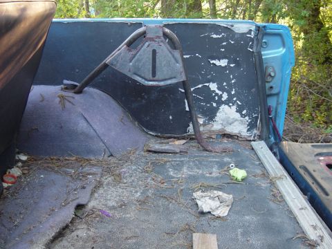 1979 Ford Bronco - The interior of a vehicle shows significant wear and tear, with debris scattered across the floor.