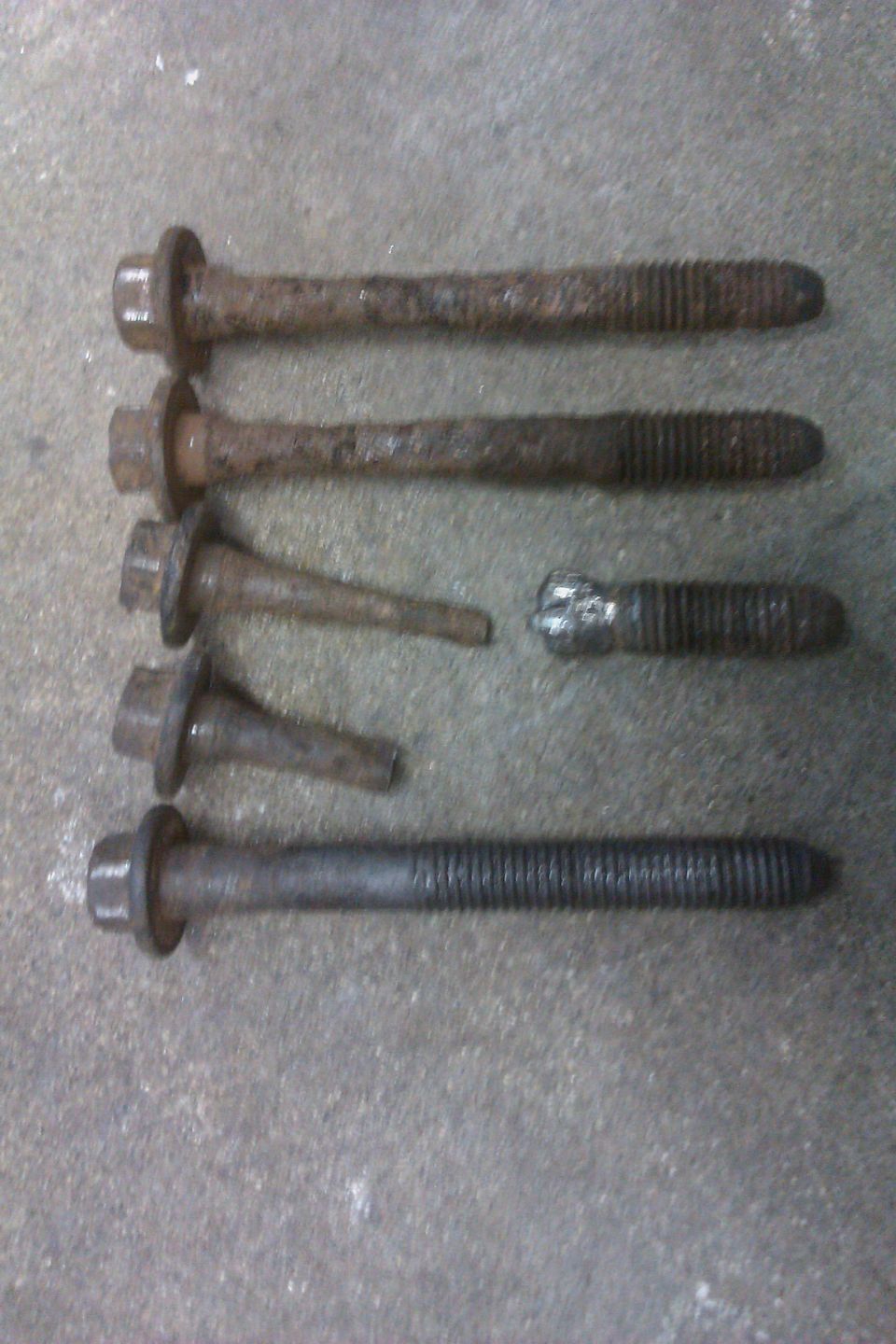 Several rusty bolts on a concrete surface