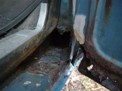 1979 Ford Bronco - Severe rust damage is visible on the door frame of this blue vehicle.