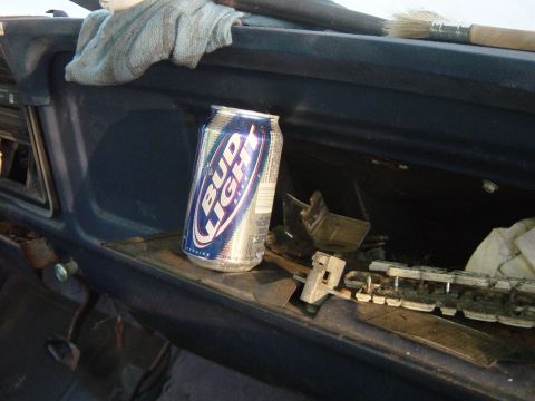 1979 Ford Bronco - A can of Bud Light rests on the dashboard of a vehicle, surrounded by debris and a paintbrush.
