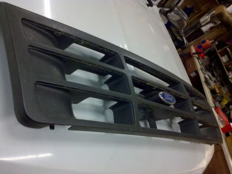 1979 Ford Bronco - A dark gray Ford grille with a blue oval emblem is shown from an angled perspective.
