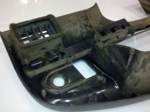 1979 Ford Bronco - This is a close-up view of a dusty interior car part, likely a dashboard section with an air vent.