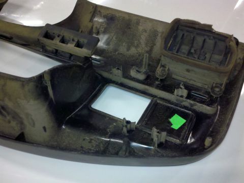 1979 Ford Bronco - A dusty black plastic dashboard trim piece with air vents and an empty square opening is shown.