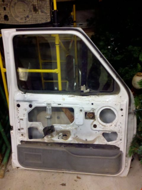 1979 Ford Bronco - A disassembled white car door is shown, revealing its internal components and door panel.