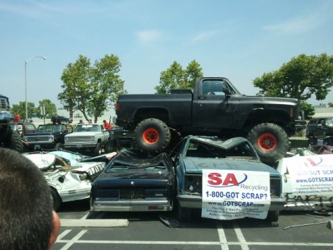 1978 Ford Bronco - A junkyard scene with multiple wrecked vehicles and a lifted pickup truck on top.