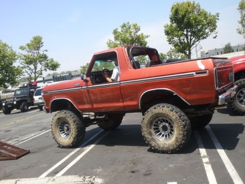 1978 Ford Bronco - Lifted 1978 Ford Bronco with aftermarket wheels and tires. A black Jeep is parked behind it.