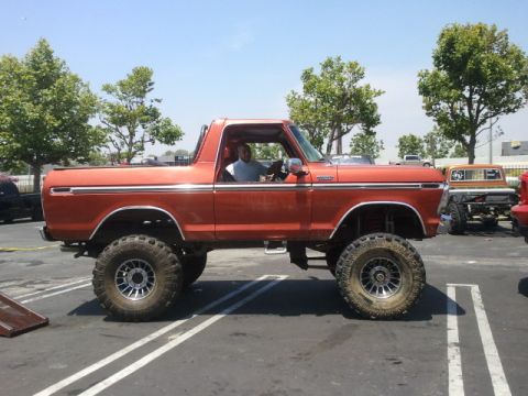 1978 Ford Bronco - This lifted 1978 Ford Bronco features a bright orange exterior and prominent chrome accents.