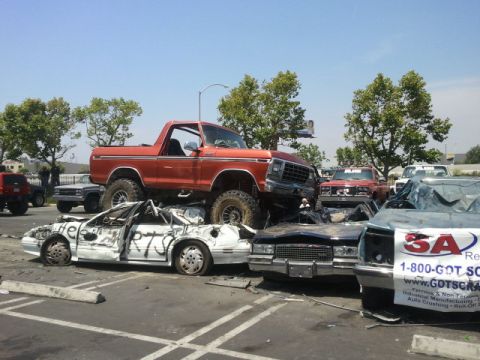 1978 Ford Bronco - This lifted 1978 Ford Bronco is perched atop a pile of wrecked vehicles, likely at a scrapyard.