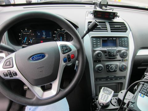 1991 Ford LTD Crown Victoria - Interior dash of a Ford vehicle showing the steering wheel, gauges, center stack and a mounted police radio control head.