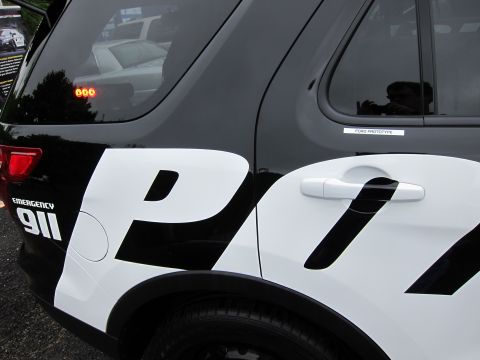 1991 Ford LTD Crown Victoria - Rear quarter panel of a black-and-white police SUV with EMERGENCY 911 and large P lettering, a Ford Prototype label visible.