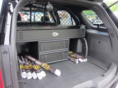 1991 Ford LTD Crown Victoria - cargo bay of a police SUV outfitted with a partition cage, storage drawers and several rolled poster tubes.