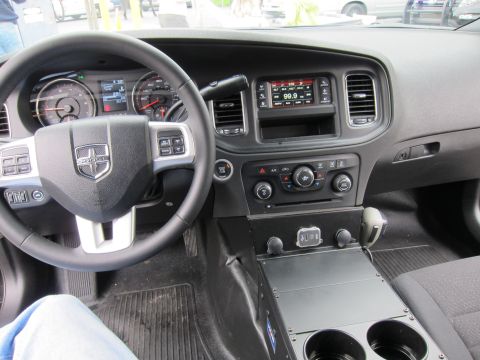 1991 Ford LTD Crown Victoria - Dodge sedan dashboard view showing the ram-head wheel emblem, gauge cluster, center radio screen and console controls.
