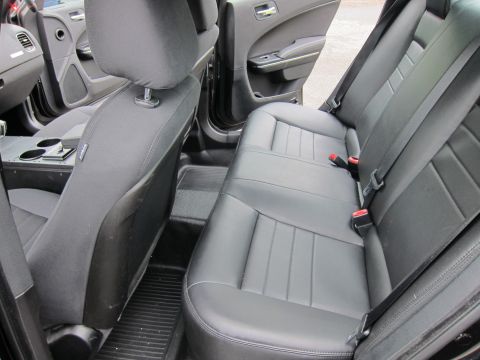1991 Ford LTD Crown Victoria - rear bench seat of a sedan, upholstered in dark leather and cloth with visible seatbelt buckles.