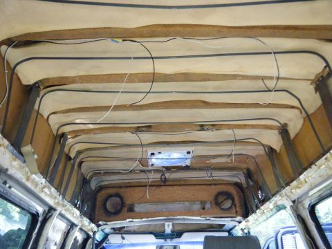 1981 Ford E350 - The interior of a van shows exposed insulation and wiring, indicating ongoing construction or renovation.