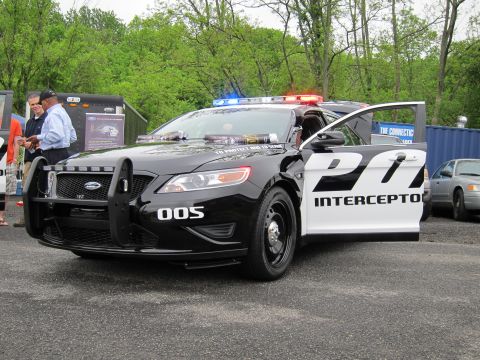 1991 Ford LTD Crown Victoria - black-and-white Ford Police Interceptor sedan with a front push bar, open door and active light bar, marked PD Interceptor and 005.