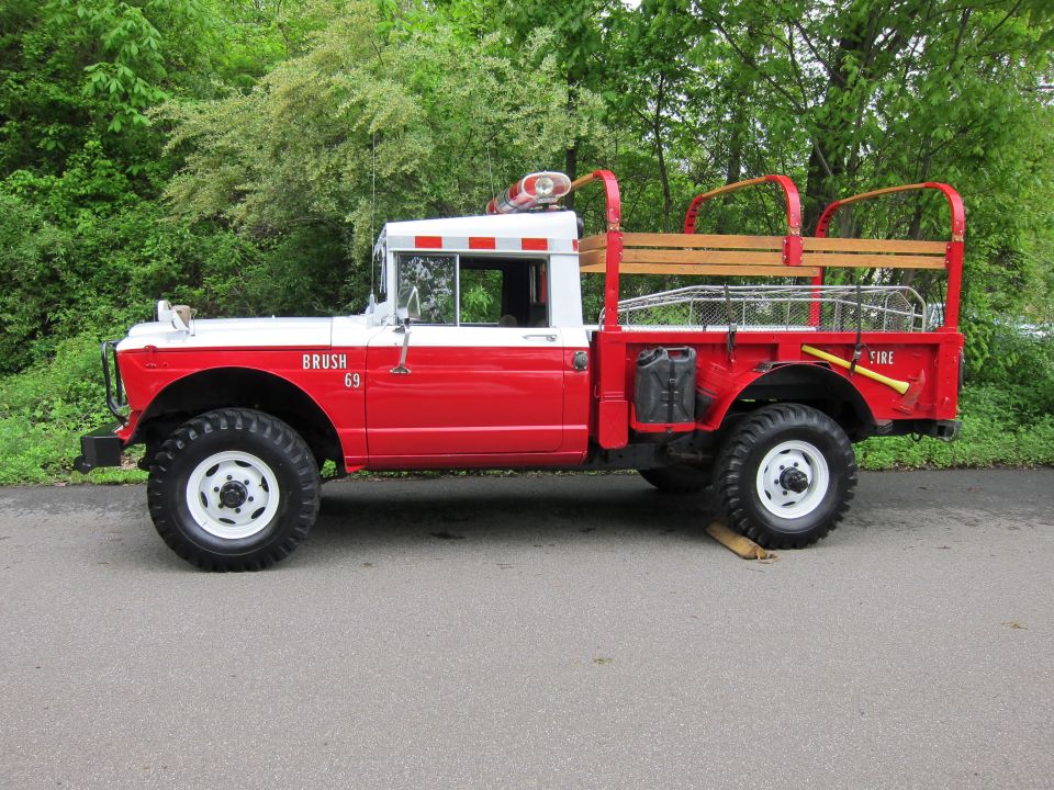 Red and white vintage 4x4 fire brush truck side view marked Brush 69