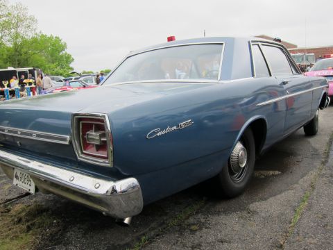 1991 Ford LTD Crown Victoria - Rear three-quarter view of a blue Ford Custom 500 sedan parked on grass at an outdoor car show.