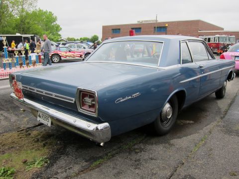 1991 Ford LTD Crown Victoria - Rear view of a blue Ford Custom 500 sedan with show spectators and a brick building in the background.