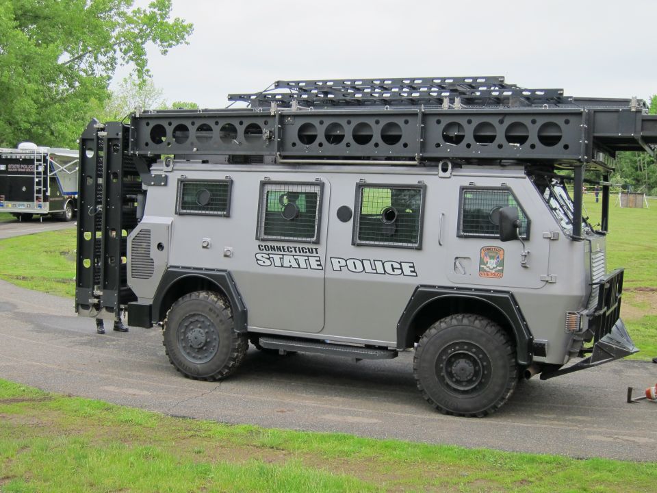 Side view of gray Connecticut State Police armored 4x4 truck on grass