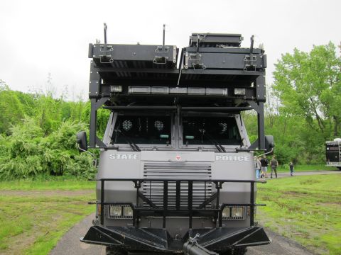 1991 Ford LTD Crown Victoria - Direct front view of a gray STATE POLICE armored truck showing its grille, barred windows, and roof-mounted equipment.