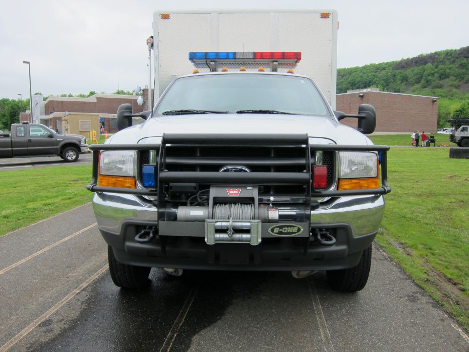 Front view of white Ford emergency truck with brush guard and winch
