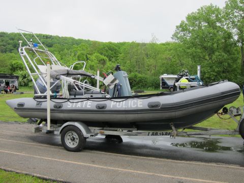 1991 Ford LTD Crown Victoria - gray rigid-hull inflatable STATE POLICE boat with a center console mounted on a single-axle trailer.