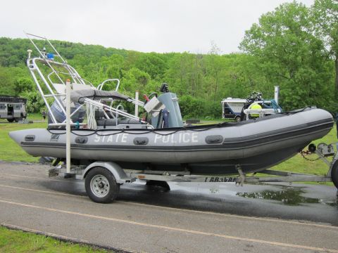 1991 Ford LTD Crown Victoria - Side view of a gray STATE POLICE rigid-hull inflatable boat with a tall radar arch, sitting on a road trailer.