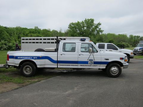 1991 Ford LTD Crown Victoria - Driver-side view of a white Ford crew-cab dually pickup marked Hartford Police Mounted Unit with blue striping.