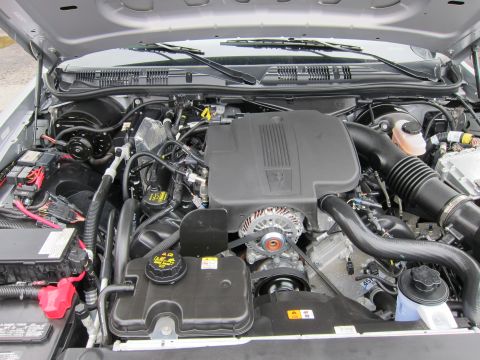 1991 Ford LTD Crown Victoria - Open engine compartment of a sedan showing the V8 engine, air intake, battery, and coolant reservoir under the hood.